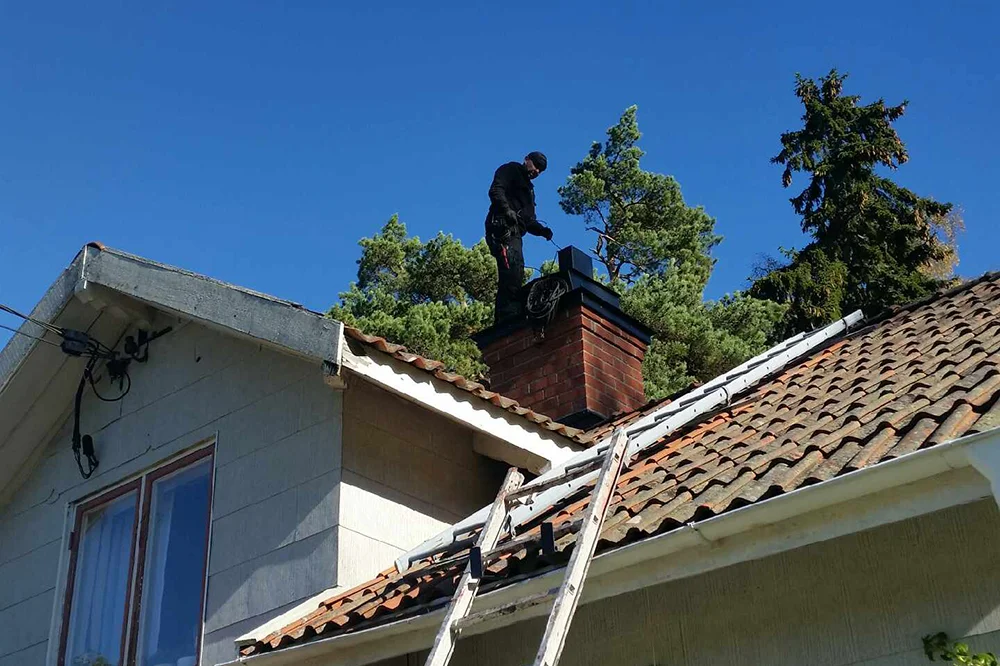 Sotning av rökkanal – sotare i arbete